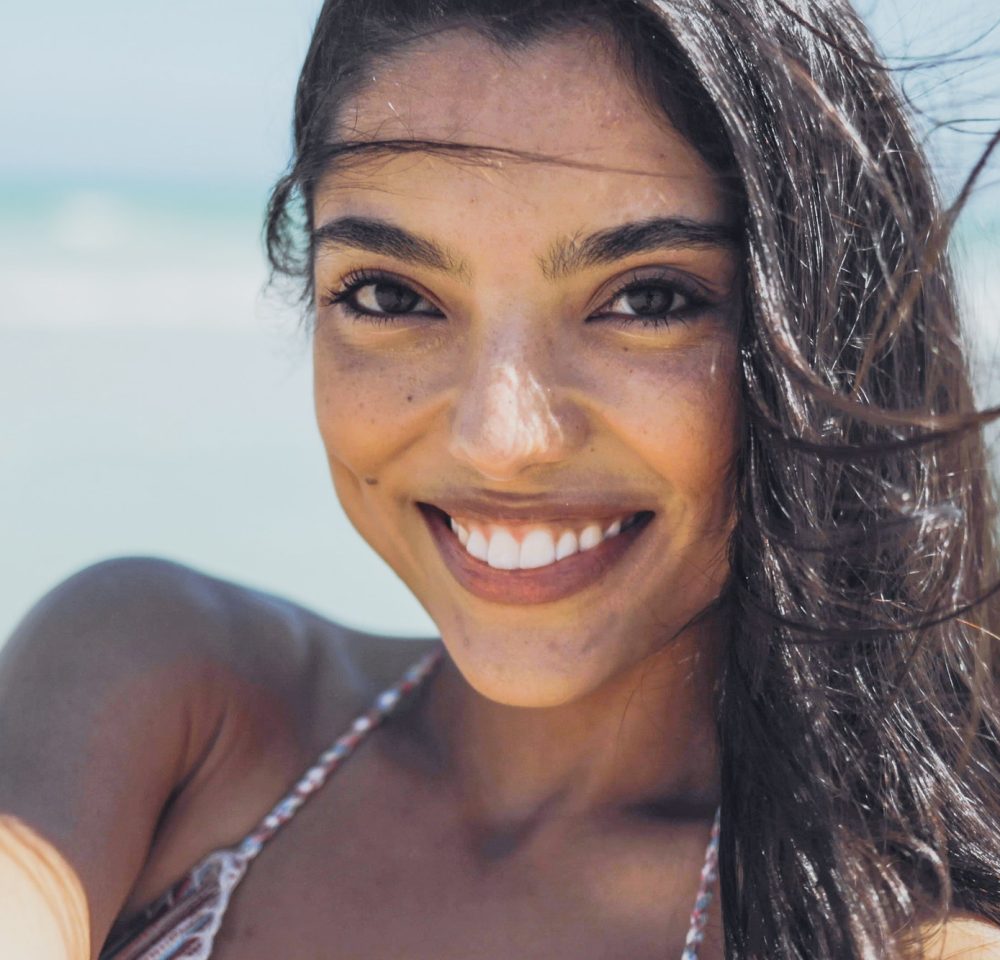 Charming ethnic woman on windy beach